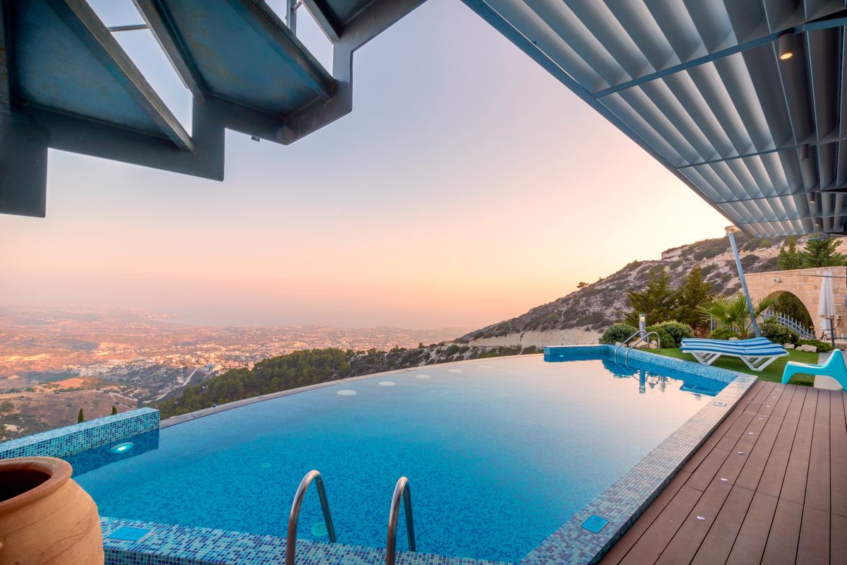 Piscine à débordement avec vue panoramique au coucher du soleil